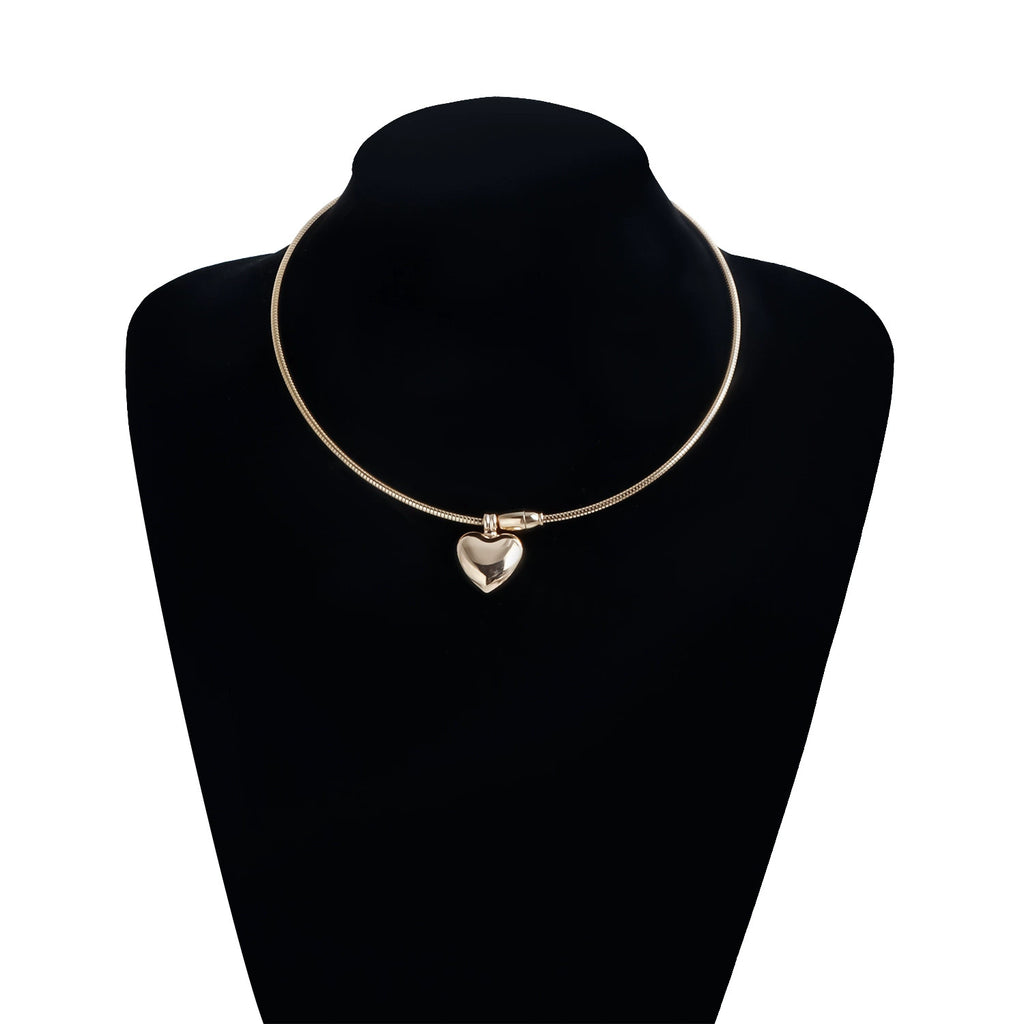 Gold heart pendant necklace displayed on a black jewellery bust